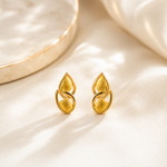 Gold earrings on a beige fabric background